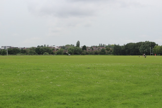 Athletics track surrounding various athletic setups with a playing field and tennis courts adjacent.