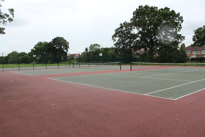 Athletics track surrounding various athletic setups with a playing field and tennis courts adjacent.