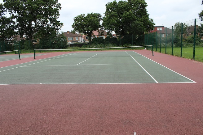 Athletics track surrounding various athletic setups with a playing field and tennis courts adjacent.