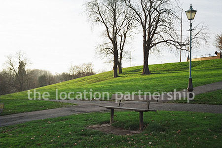 Bench on hill overlooking parkland and views of London