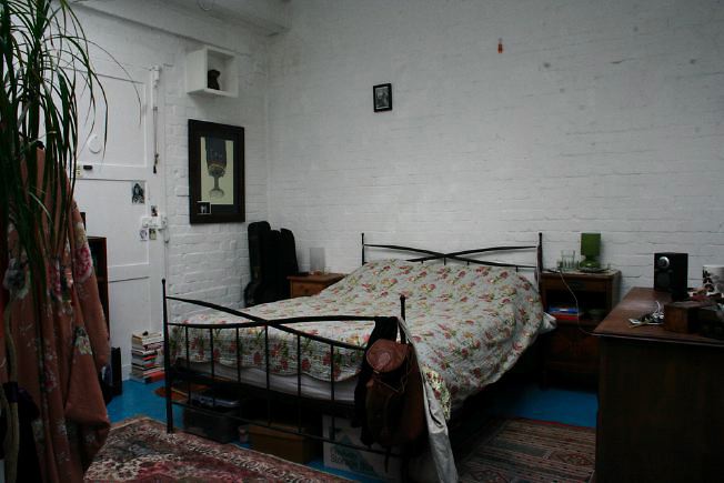 Workshop converted into a flat on one level with 4 bedrooms, concrete floors and exposed brick walls.