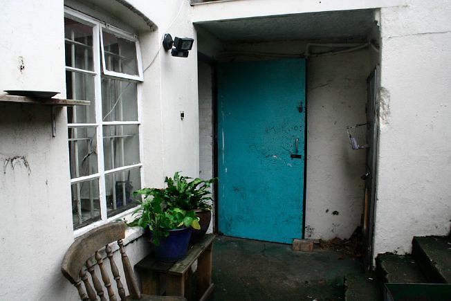Workshop converted into a flat on one level with 4 bedrooms, concrete floors and exposed brick walls.