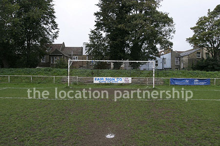 Classic traditional small football ground surrounded by houses.