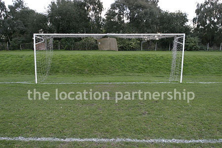 Football / cricket pitches with semi-urban backdrop and pavillion.