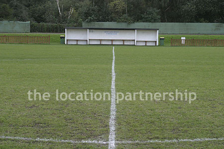 Football / cricket pitches with semi-urban backdrop and pavillion.