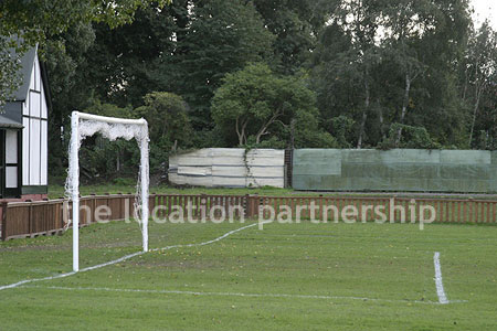 Football / cricket pitches with semi-urban backdrop and pavillion.