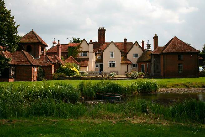 Characterful exterior and gardens of beautiful country house with treehouse, outbuildings, barns, swimming pool and tennis court.