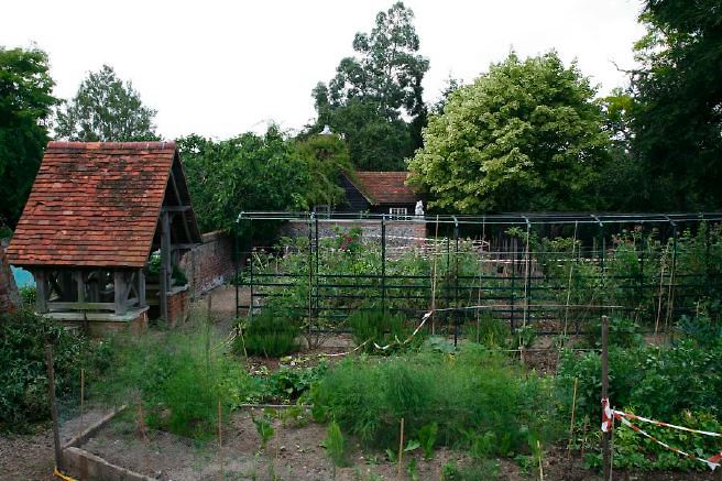 Characterful exterior and gardens of beautiful country house with treehouse, outbuildings, barns, swimming pool and tennis court.