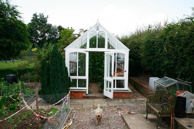 Characterful exterior and gardens of beautiful country house with treehouse, outbuildings, barns, swimming pool and tennis court.