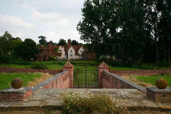 Characterful exterior and gardens of beautiful country house with treehouse, outbuildings, barns, swimming pool and tennis court.