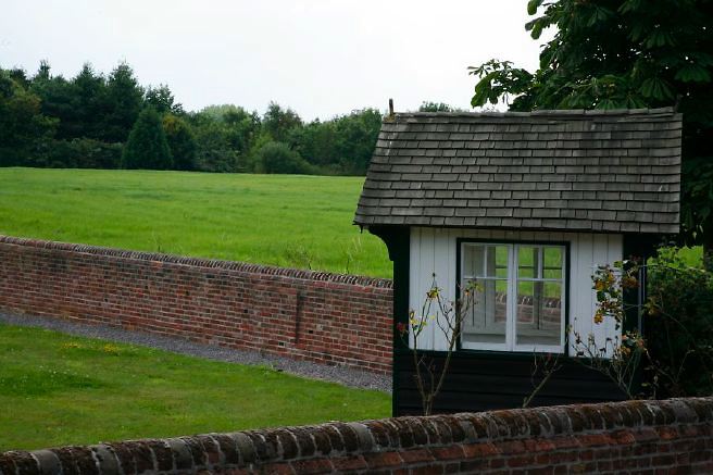 Characterful exterior and gardens of beautiful country house with treehouse, outbuildings, barns, swimming pool and tennis court.