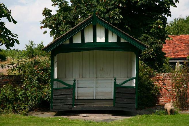 Characterful exterior and gardens of beautiful country house with treehouse, outbuildings, barns, swimming pool and tennis court.