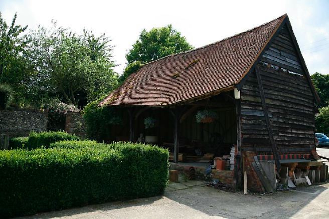 Characterful exterior and gardens of beautiful country house with treehouse, outbuildings, barns, swimming pool and tennis court.