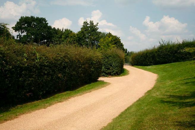 Characterful exterior and gardens of beautiful country house with treehouse, outbuildings, barns, swimming pool and tennis court.