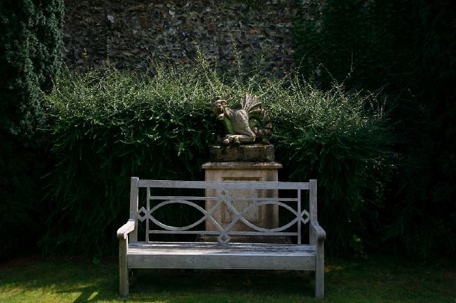 Characterful exterior and gardens of beautiful country house with treehouse, outbuildings, barns, swimming pool and tennis court.