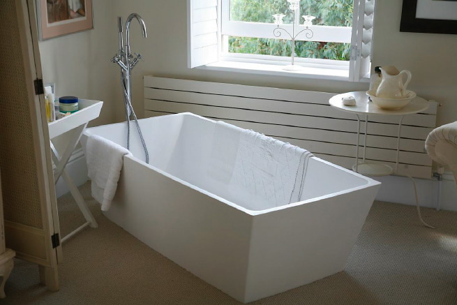 Great contemporary free-standing bath in a huge light bedroom with plantation shutters and a separate en-suite.