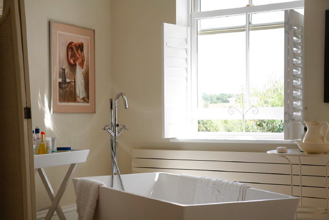 Great contemporary free-standing bath in a huge light bedroom with plantation shutters and a separate en-suite.