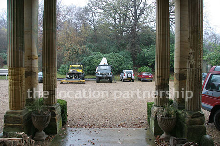 Gravel driveway leading to a pillared portico at the entrance to a large Country House