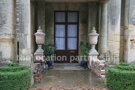 Gravel driveway leading to a pillared portico at the entrance to a large Country House
