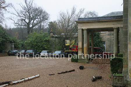 Gravel driveway leading to a pillared portico at the entrance to a large Country House