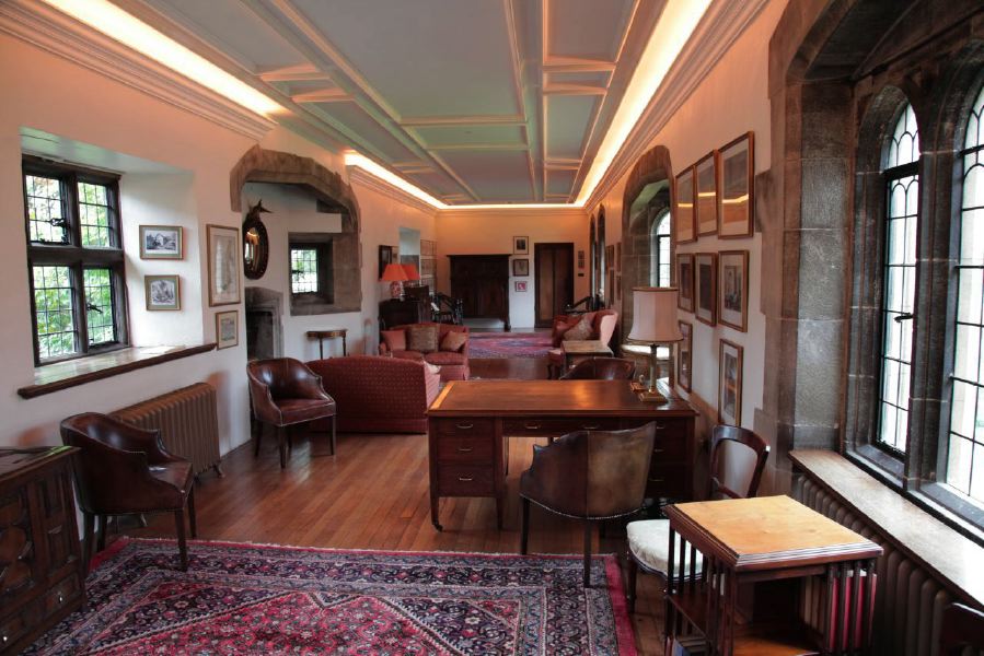 Sitting room with beautiful stone mullion windows in a historic house