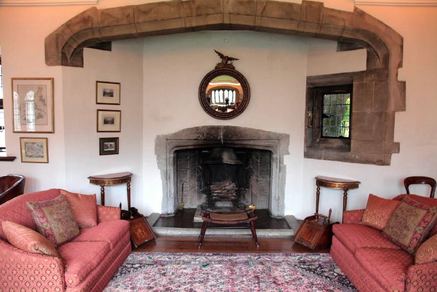 Sitting room with beautiful stone mullion windows in a historic house