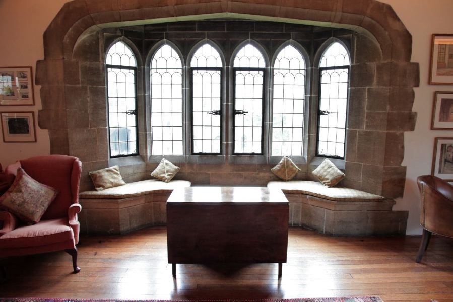 Sitting room with beautiful stone mullion windows in a historic house