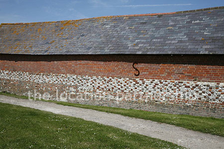 Walled flower and vegetable garden with variety of greenhouses