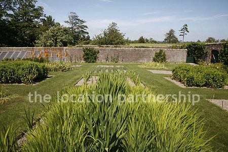 Walled flower and vegetable garden with variety of greenhouses