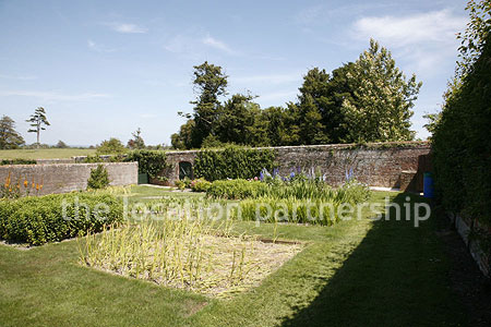 Walled flower and vegetable garden with variety of greenhouses