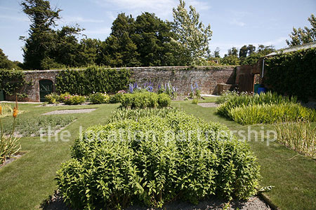 Walled flower and vegetable garden with variety of greenhouses