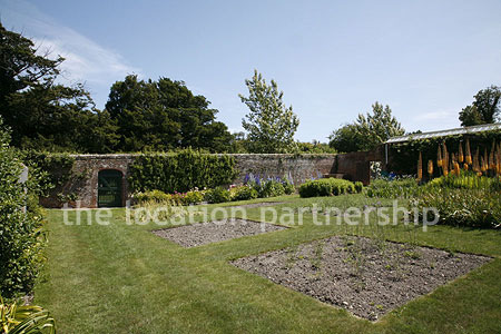 Walled flower and vegetable garden with variety of greenhouses