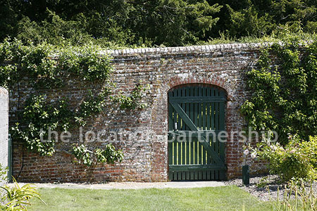 Walled flower and vegetable garden with variety of greenhouses