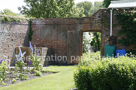 Walled flower and vegetable garden with variety of greenhouses