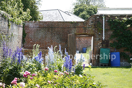 Walled flower and vegetable garden with variety of greenhouses