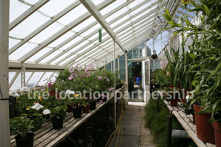 Walled flower and vegetable garden with variety of greenhouses