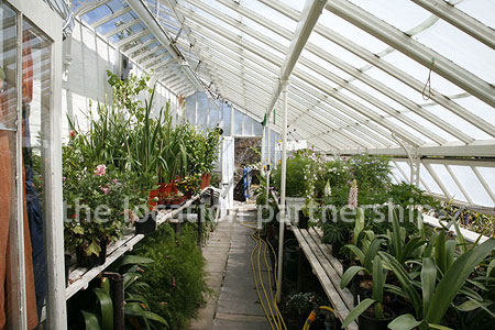 Walled flower and vegetable garden with variety of greenhouses
