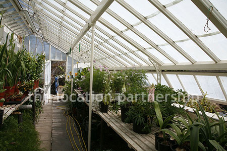 Walled flower and vegetable garden with variety of greenhouses