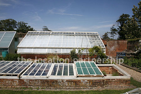 Walled flower and vegetable garden with variety of greenhouses