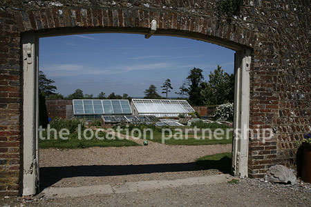 Walled flower and vegetable garden with variety of greenhouses