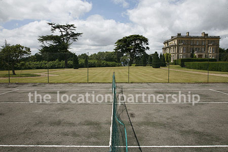 Private tennis court in the grounds of a country mansion.