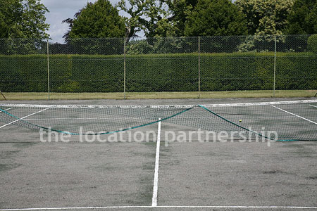Private tennis court in the grounds of a country mansion.