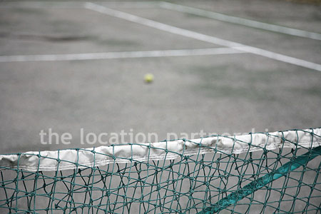 Private tennis court in the grounds of a country mansion.