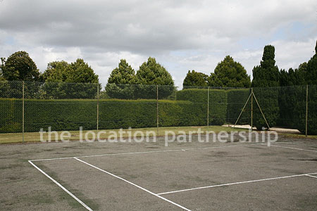 Private tennis court in the grounds of a country mansion.