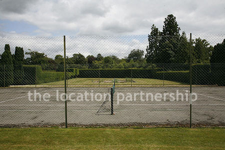 Private tennis court in the grounds of a country mansion.