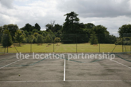 Private tennis court in the grounds of a country mansion.