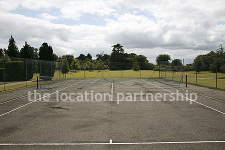 Private tennis court in the grounds of a country mansion.
