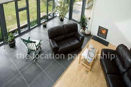 Double height sitting room/ conservatory with full length windows and overhead skylight.