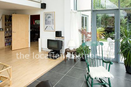 Double height sitting room/ conservatory with full length windows and overhead skylight.