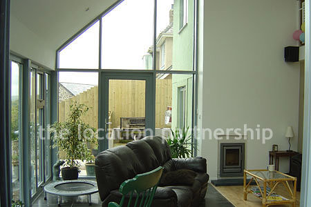 Double height sitting room/ conservatory with full length windows and overhead skylight.